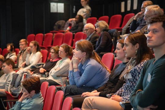 Das Foto zeigt gefüllte Publikumsreihen im Hörsaal des BNITM.