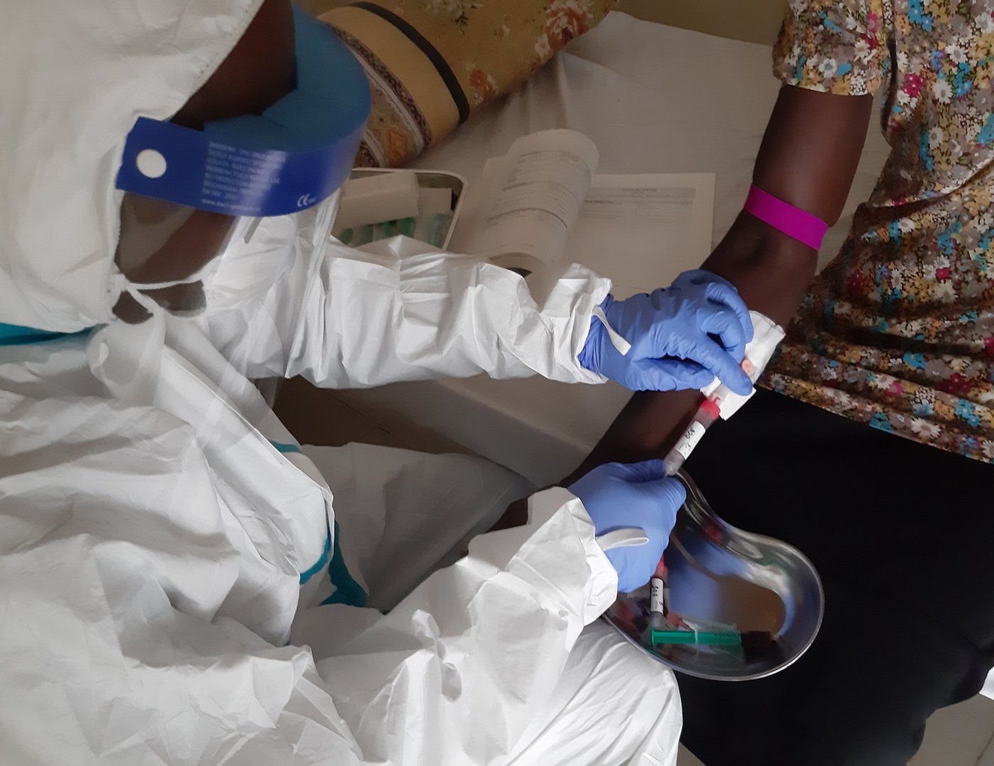 The picture shows a study doctor in the isolation ward drawing blood for the pharmacokinetic analysis of the Lassa fever study.