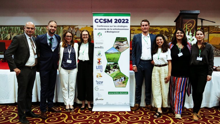 [Translate to English:] Labgroup Fusco im CCSM 2022 (eine Gruppe von Menschen, die neben einem Roll-up stehen und in die Kamera lächeln)