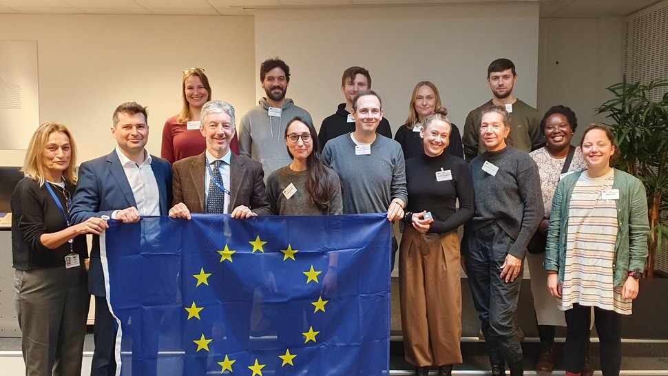 EMLab-Besuch der Europäischen Kommission, Brüssel, Dezember 2023 Das Foto zeigt eine Gruppe Menschen mit einer EU-Flagge in der Hand.