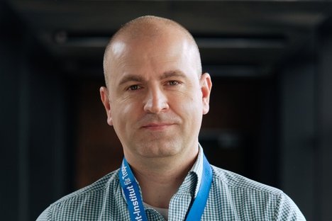 Dr. Dániel Cadar Dr. Dániel Cadar: ein Forscher, der ein blau-weiß kariertes Hemd trägt und eine Glatze hat.