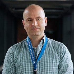 Dr Dániel Cadar: a researcher who wears a blue and white checked shirt and is bald.