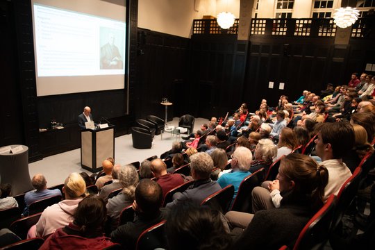 Podiumsdiskussion über Bernhard Nocht Das Foto zeigt den vollen Hörsaal von schräg links oben. Unten vorn am Pult steht ein Redner.