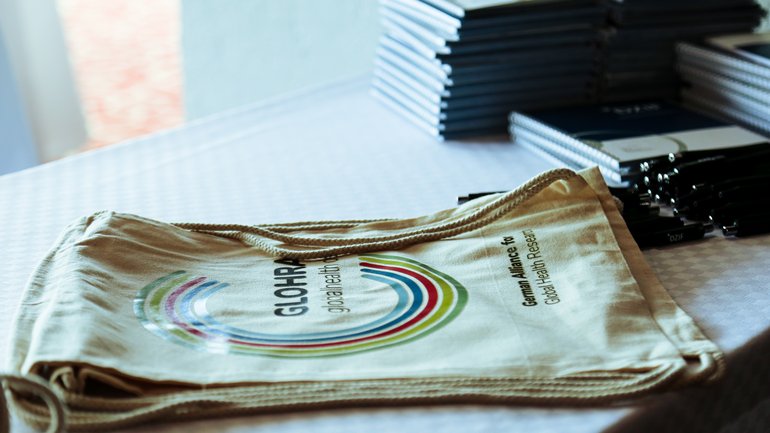 [Translate to English:] Taschen und Notizbücher von Sponsoren zur Verteilung auf der Konferenz (Werbetaschen und Notizbücher auf einem Tisch)