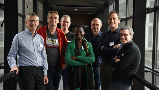 Das Bild zeigt eine internationale Gruppe von Forscher:innen im Glasübergang zwischen Alt- und Neubau des BNITM, die Keynote speaker des Malariameetings