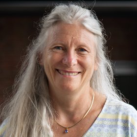 Ph.D. Elisabeth Fichet-Calvet: eine Forscherin mit langen, weißblonden Haaren und legerem T-shirt.