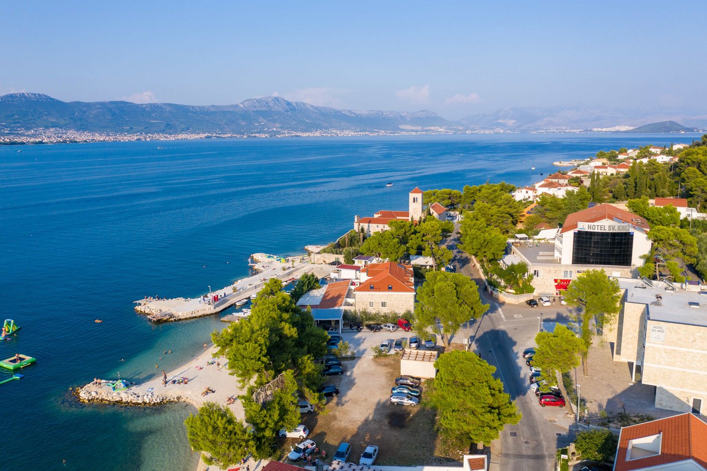 The conference site located at the sea: The view from Hotel Sveti. You can see the rocky coast of Croatia, blue sea and in the background mountains rising green above the horizon.