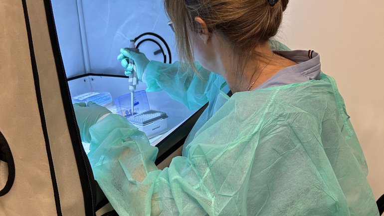 Person pipettiert Proben in einer tragbaren Laborstation