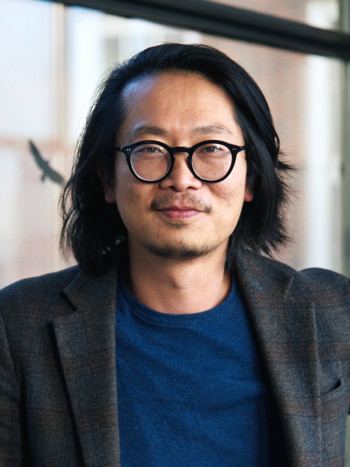 Dr. Sung-Joon Park Dr. Sung-Joon Park: ein Forscher der schulterlanges Haar, eine runde schwarze Brille, ein dunkles Sakko über einem dunkelblauen Oberteil trägt.
