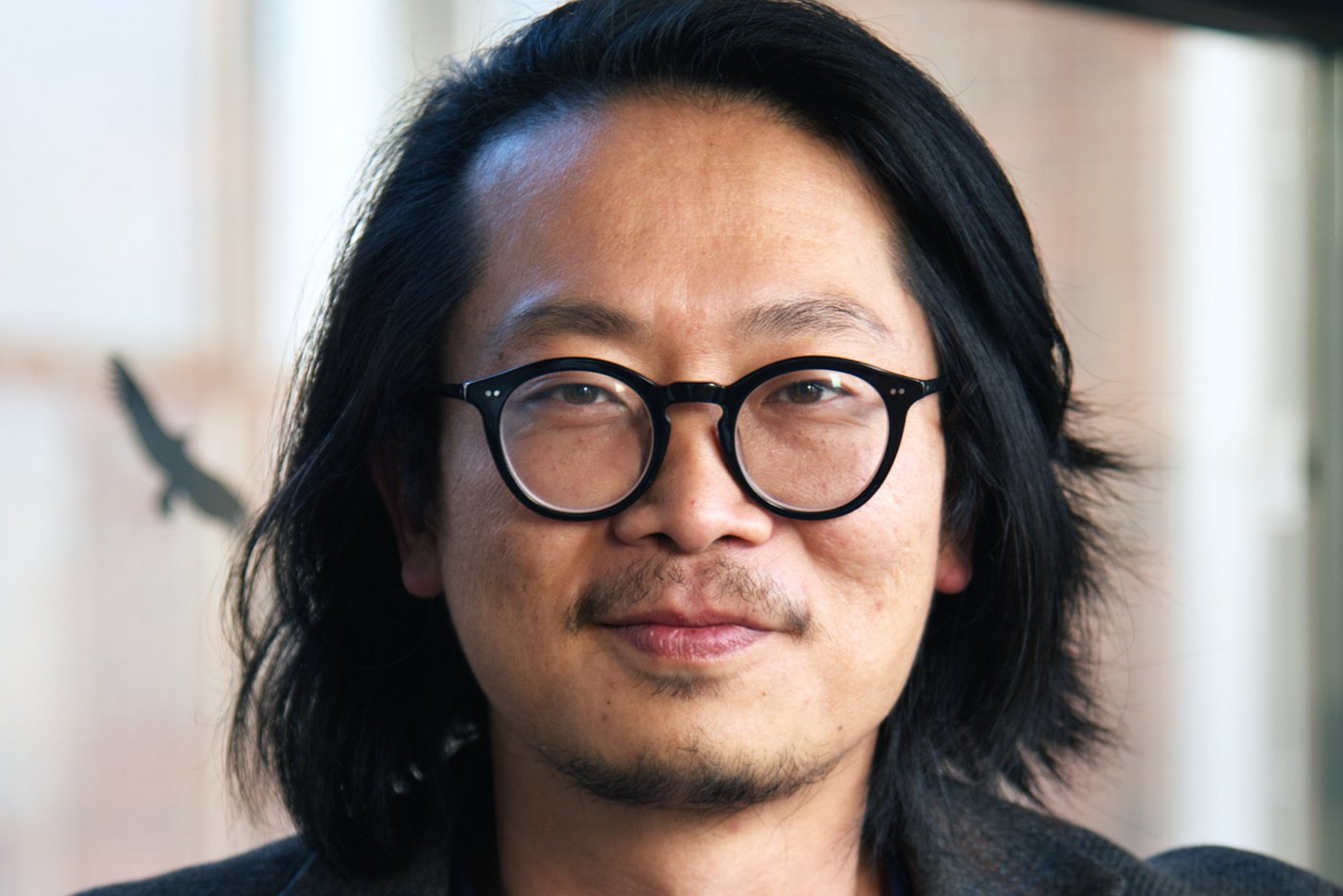Dr. Sung-Joon Park Dr. Sung-Joon Park: ein Forscher der schulterlanges Haar, eine runde schwarze Brille, ein dunkles Sakko über einem dunkelblauen Oberteil trägt.