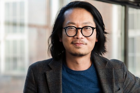 Dr. Sung-Joon Park Dr. Sung-Joon Park: ein Forscher der schulterlanges Haar, eine runde schwarze Brille, ein dunkles Sakko über einem dunkelblauen Oberteil trägt.