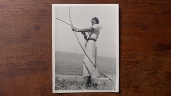 Ein Schwarzweißbild einer Person, die mit einem Bogen schießt