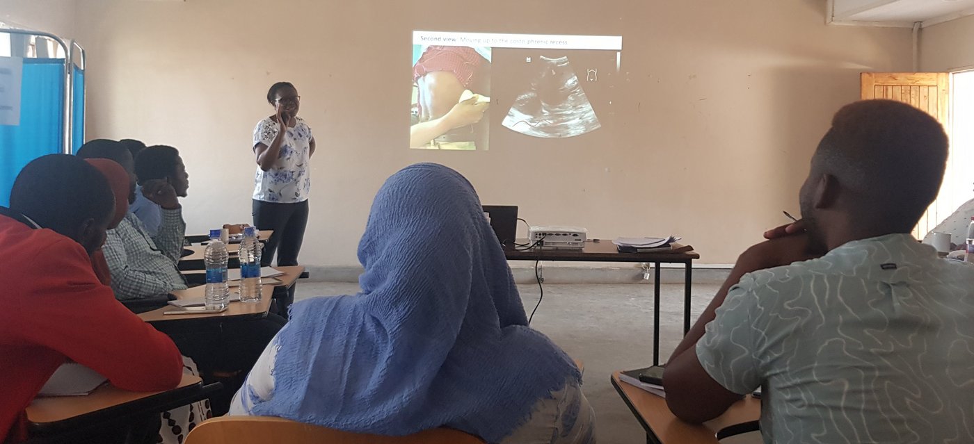 Das Bild zeigt eine Dozentin, die einen Vortrag über Ultraschall hält.