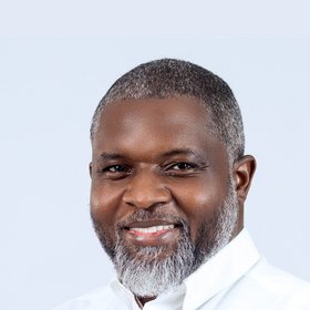 PhD John Amuasi: a researcher wearing a suit, dark short hair and a short beard.