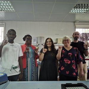 Foto von fünf Personen im Labor. Sie lächeln freundlich in die Kamera.