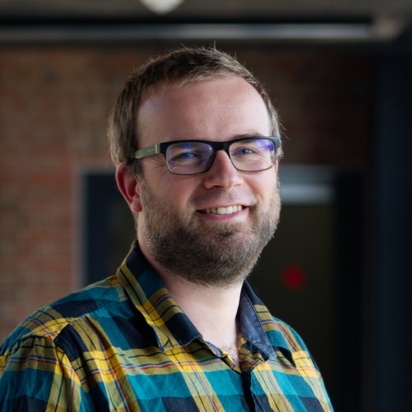 Dr Renke Lühken: a researcher wearing a green and yellow checked shirt, short dark blond hair and a short beard.