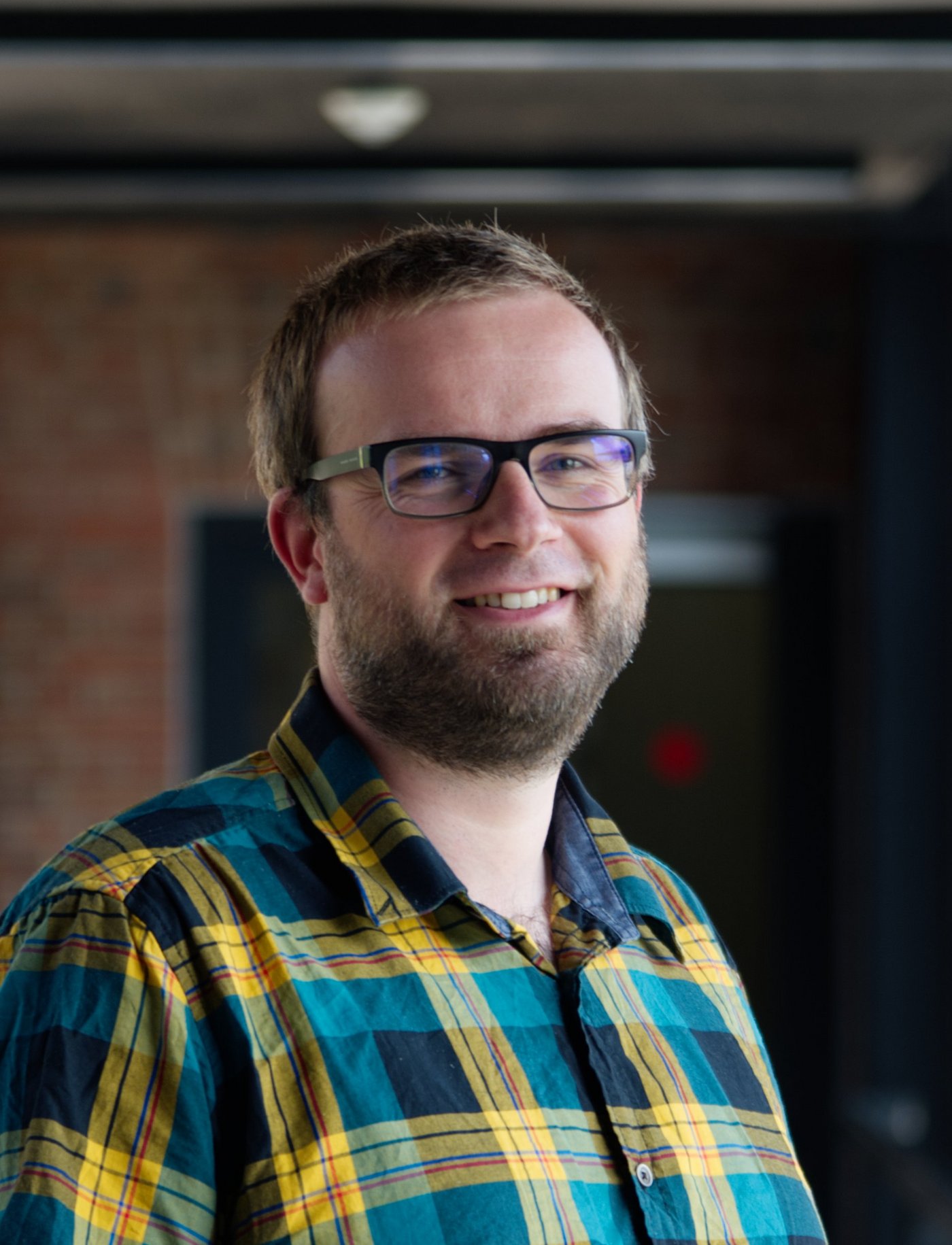 Dr Renke Lühken: a researcher wearing a green and yellow checked shirt, short dark blond hair and a short beard.