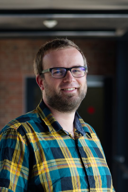 Dr. Renke Lühken Dr. Renke Lühken: ein Forscher, der ein grün-gelb kariertes Hemd, kurze, dunkelblonde Haare und einen kurzen Bart trägt.