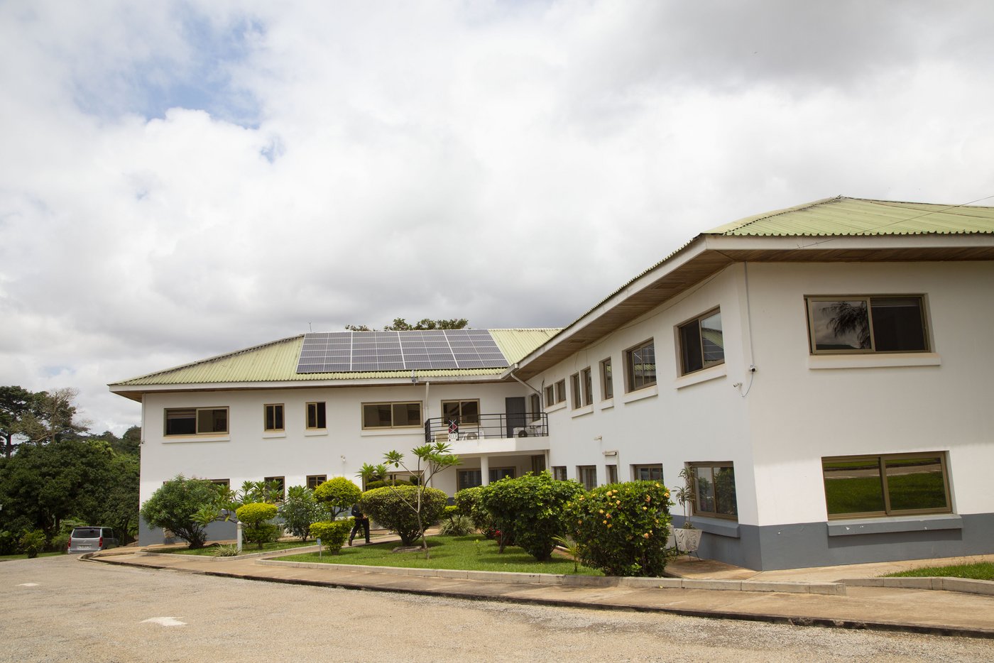 Das Bild zeigt das zweistöckige Hauptgebäude des KCCR mit hellgrünem Dach und Solaranlage.