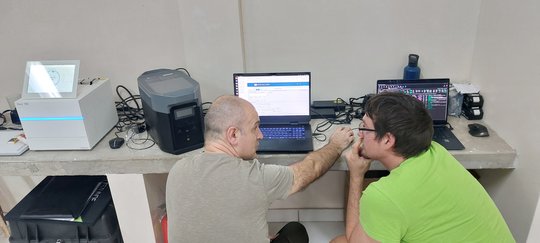 Das Foto zeigt zwei Forscher vor einem Laptop diskutieren.