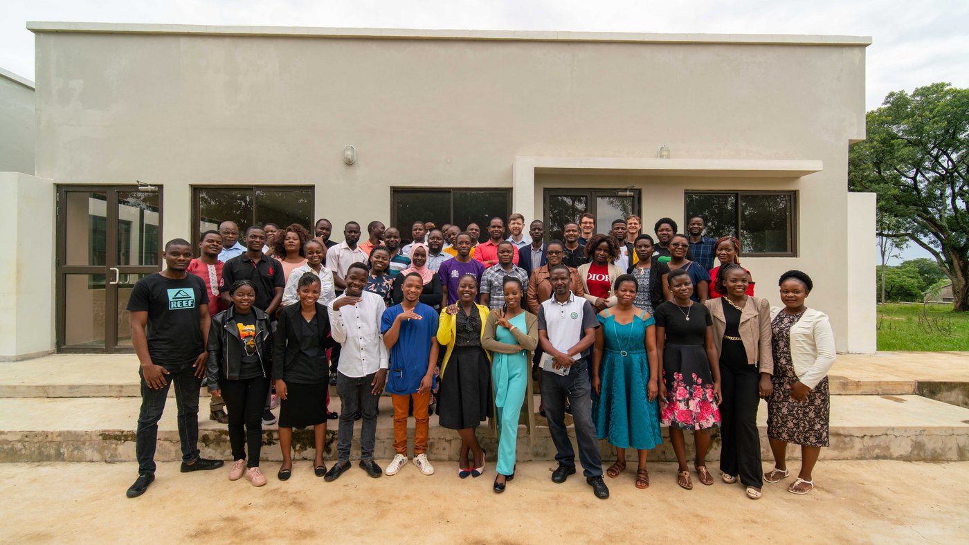 The picture shows a group of people in front of a building.