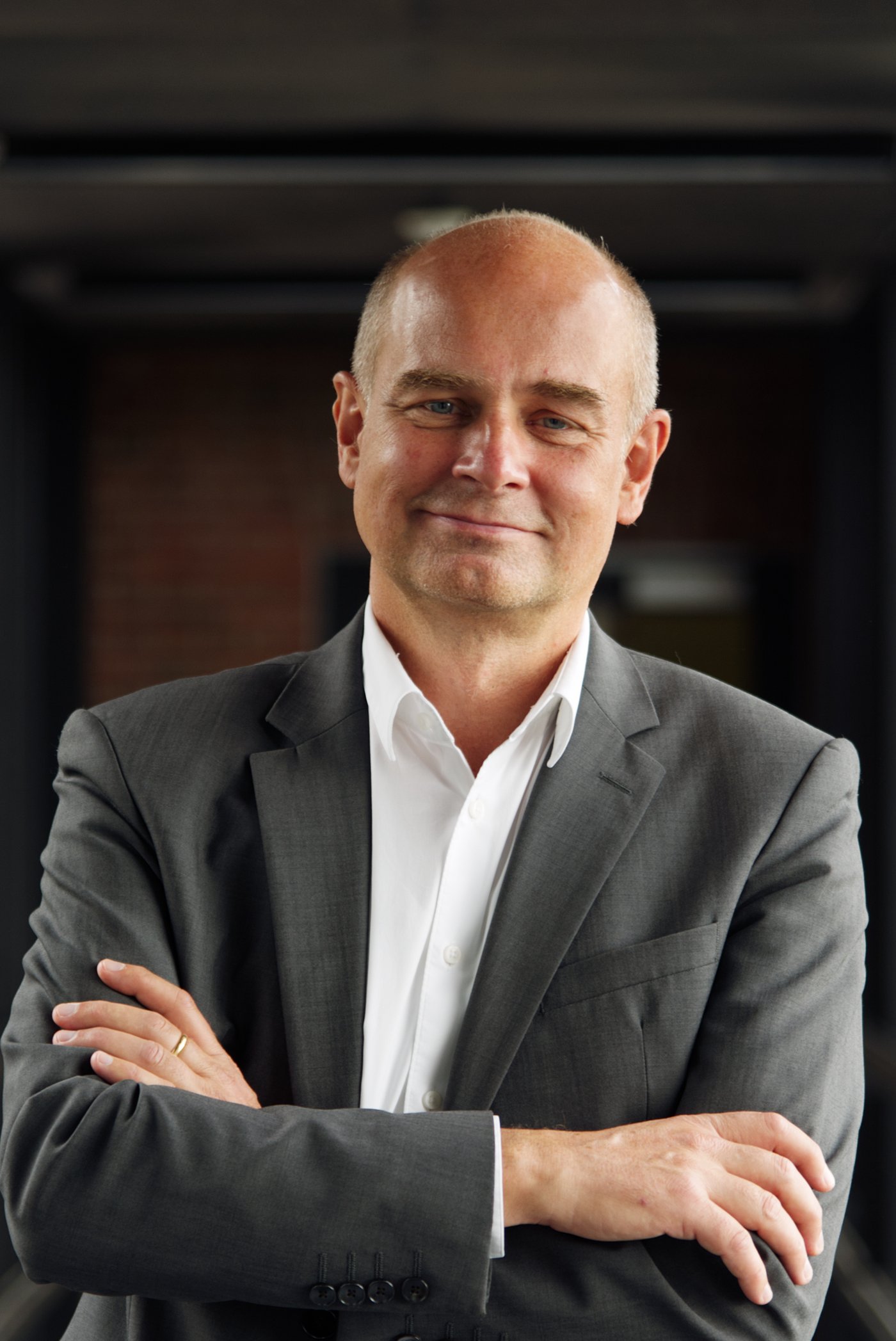 Prof. Dr. Jürgen May: a researcher who is bald and wears a white shirt with a grey jacket.