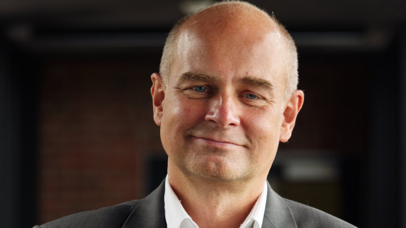 Prof. Dr Jürgen May: a researcher who is bald and wears a white shirt with a grey jacket.