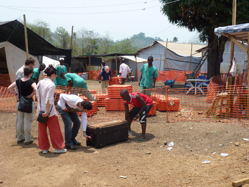 Transfer of the Lab into MSF isolation campus Das Bild zeigt diverse Personen beim Transport des EMLab-Materials in Guinea