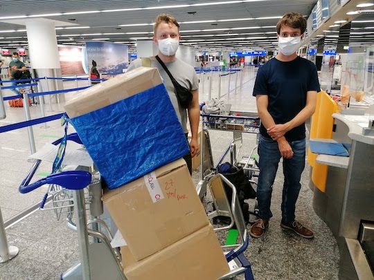 Zwei junge forscher mit Paketen und Marerialien am Flughafen auf dem Weg nach Madagaskar