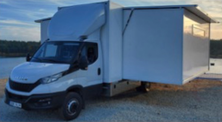 The picture shows a Sprinter with mobile attachments on both sides.