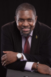 John H. Amuasi, Ph.D. Direct portrait of an African experienced researcher. He looks in a friendly manner in the direction of the viewer.