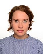 Eine Project Managerin und Clinical Monitorin mit kurzem, rötlichen Haar und einem lila Oberteil schaut in die Kamera. Der Hintergrund ist weiß.