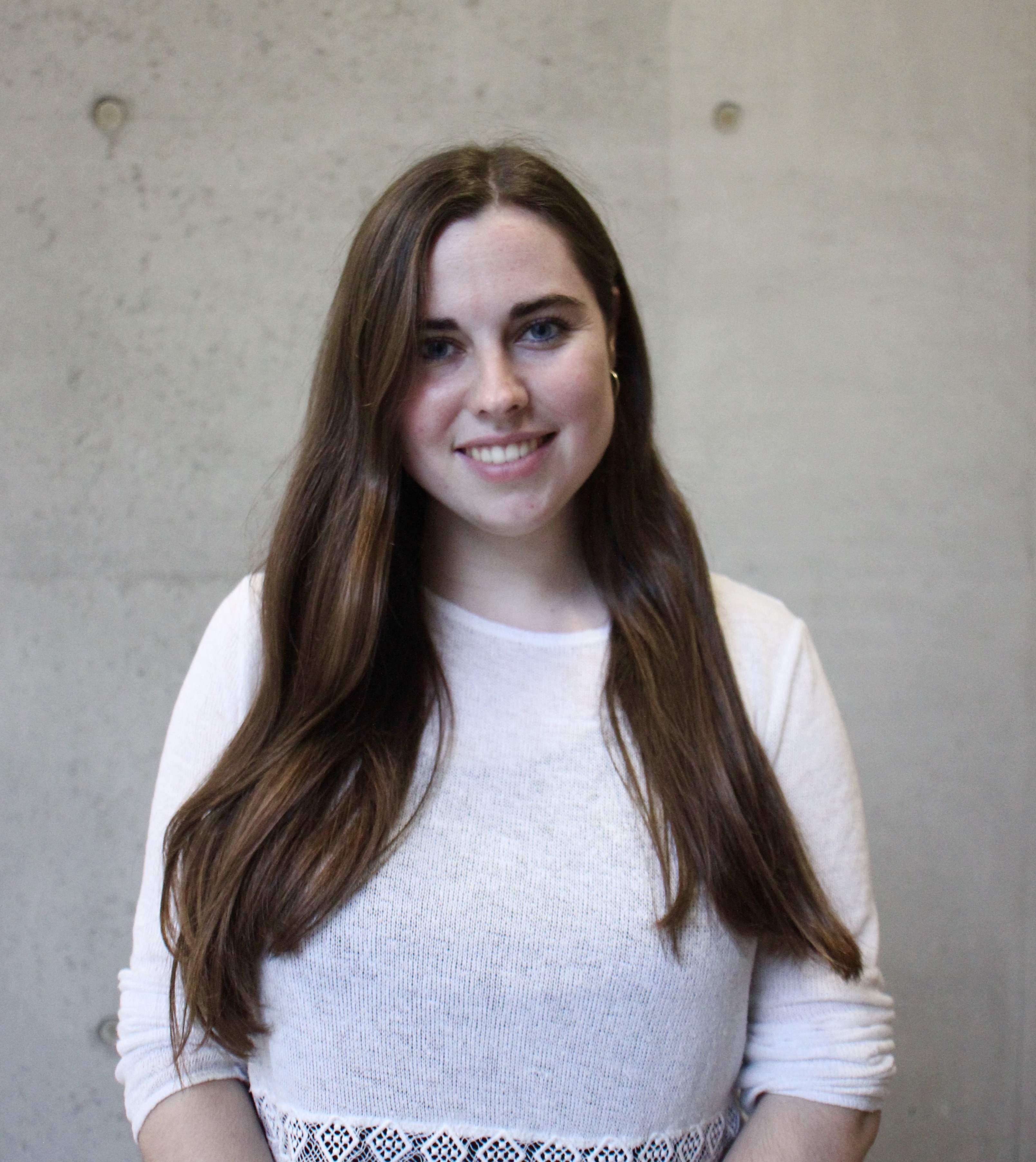 Dr. Barbara Honecker Dr. Barbara Honecker: ein Porträtfoto, das eine Forscherin mit dunklem, langem Haar und einem weißen Oberteil vor einer weißen Wand zeigt.